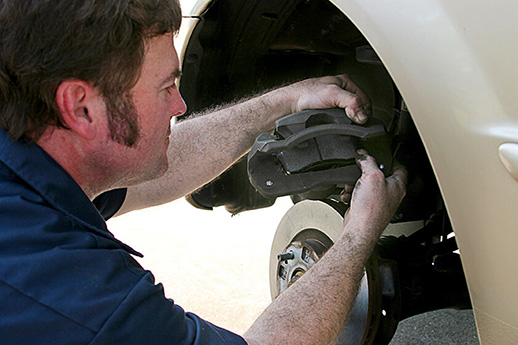 Mechanic Inserting Brake Pad